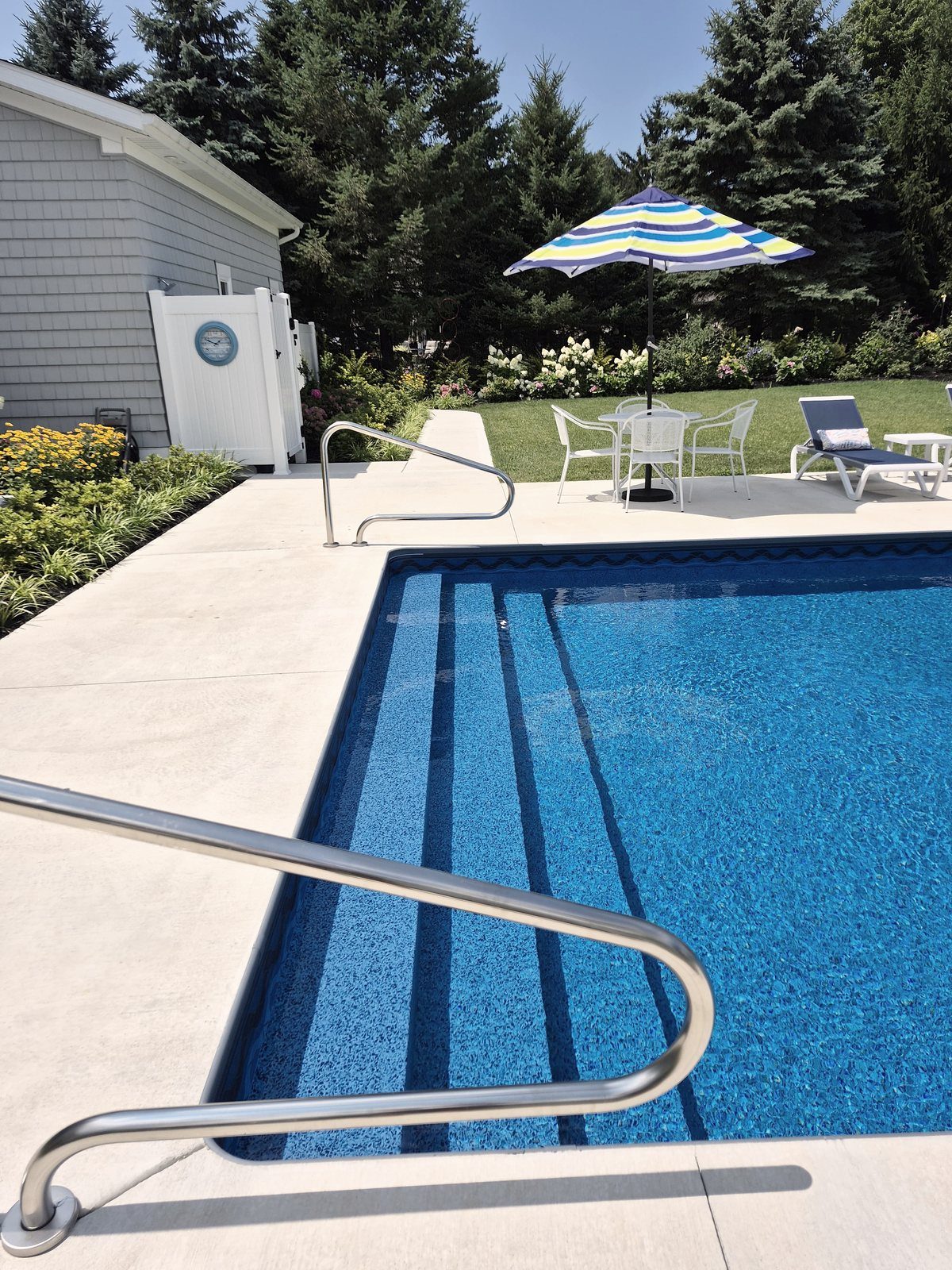 Heated saltwater pool with poolside seating and garden border